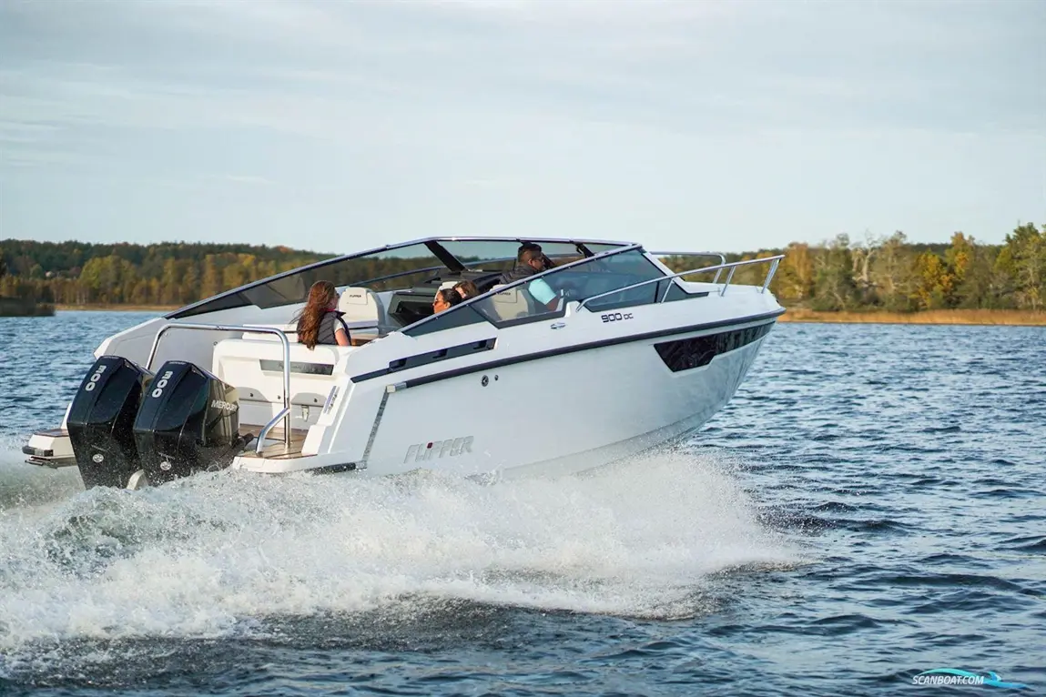 A speedboat, Flipper 900DC, cruising through a lake with three passengers enjoying the ride, splashes water behind it.